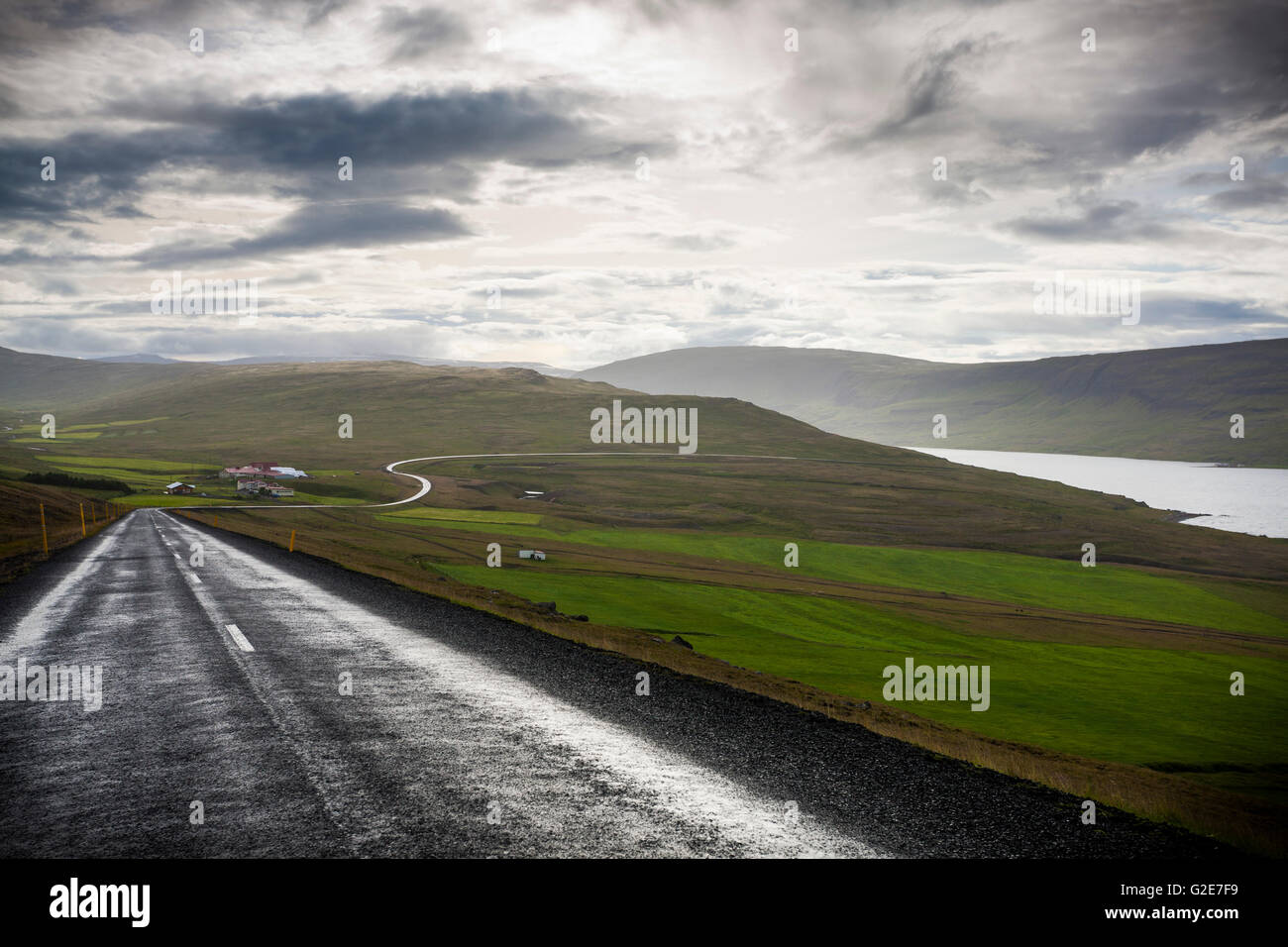 Straße entlang ländlichen Gegend in der Nähe von Meer, Island Stockfoto