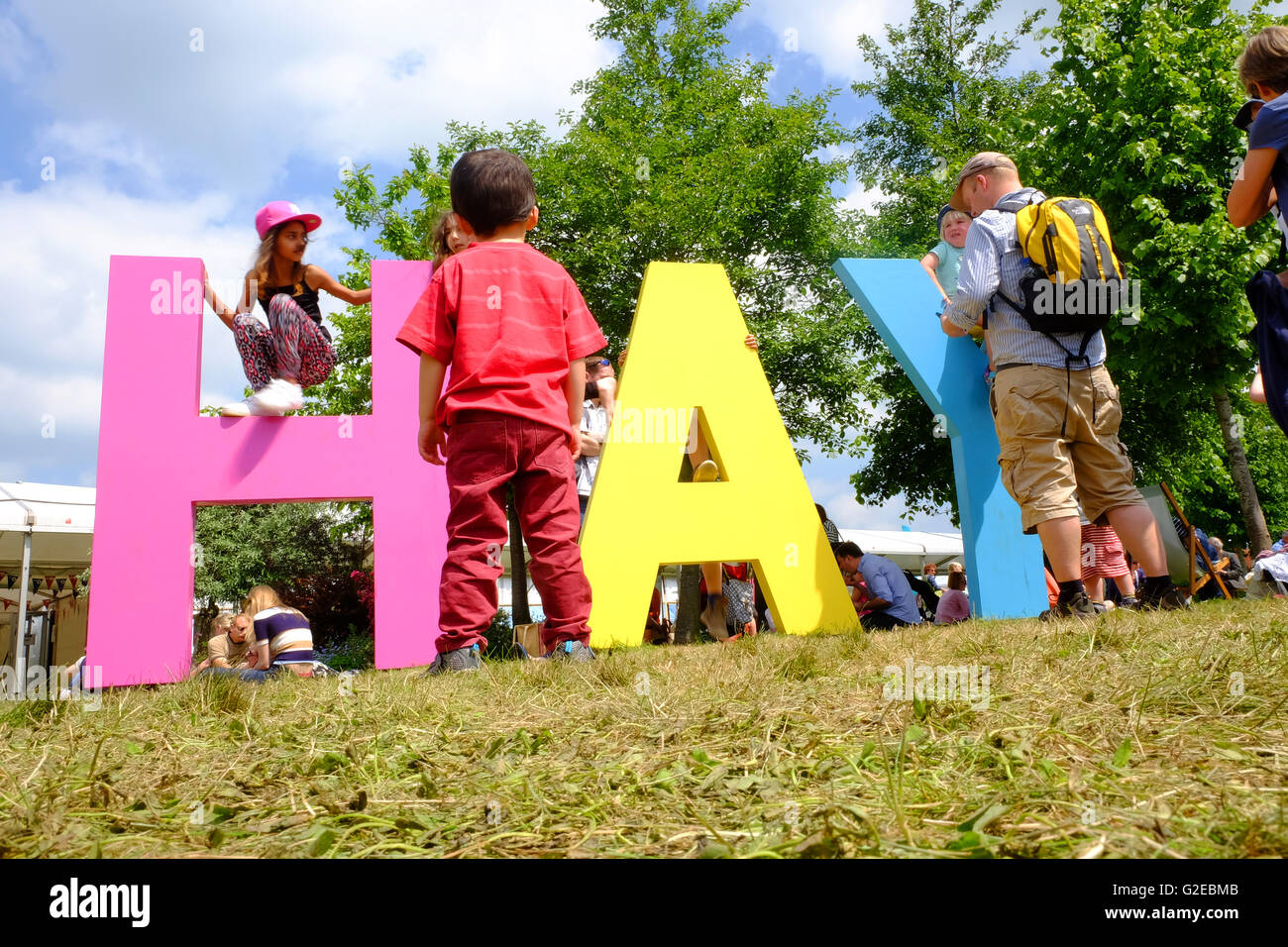 Hay Festival, Wales, Großbritannien - Mai 2016 - Junge Kinder genießen Sie die Gelegenheit, um zu laufen und auf der das Heu Book Festival Rasen in der schönen Wetter spielen. Stockfoto