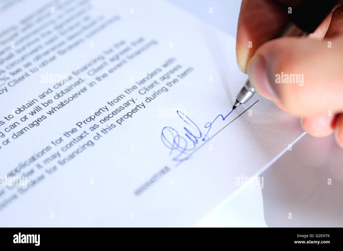 Geschäftsmann Signieren eines Dokuments auf ein Büro Tisch closeup Stockfoto