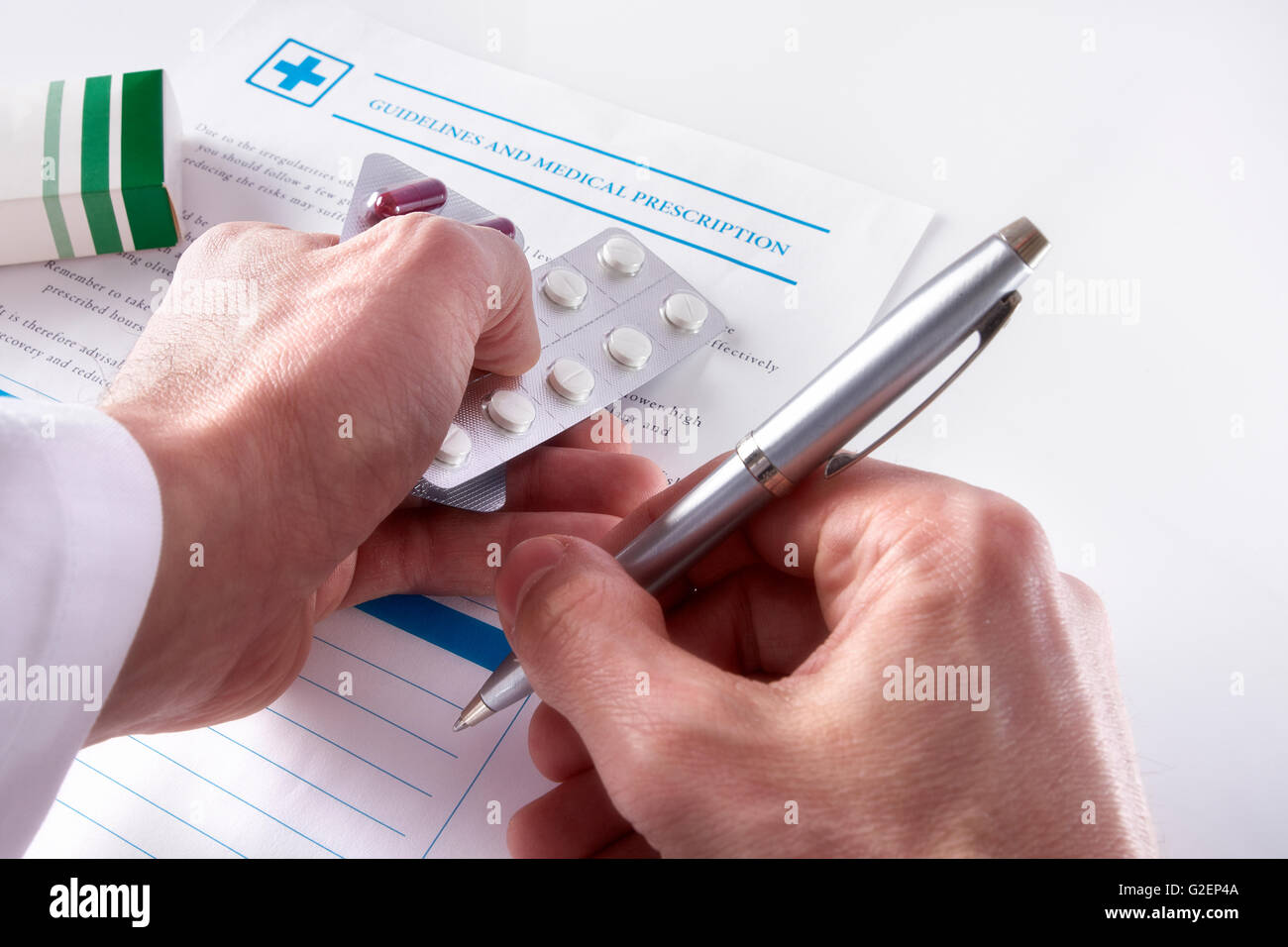Arzt eine ärztliche Verschreibung mit Dokumente und Medikamente auf einem weißen Glastisch aufschreiben. Horizontale Komposition. Erhöhte Stockfoto