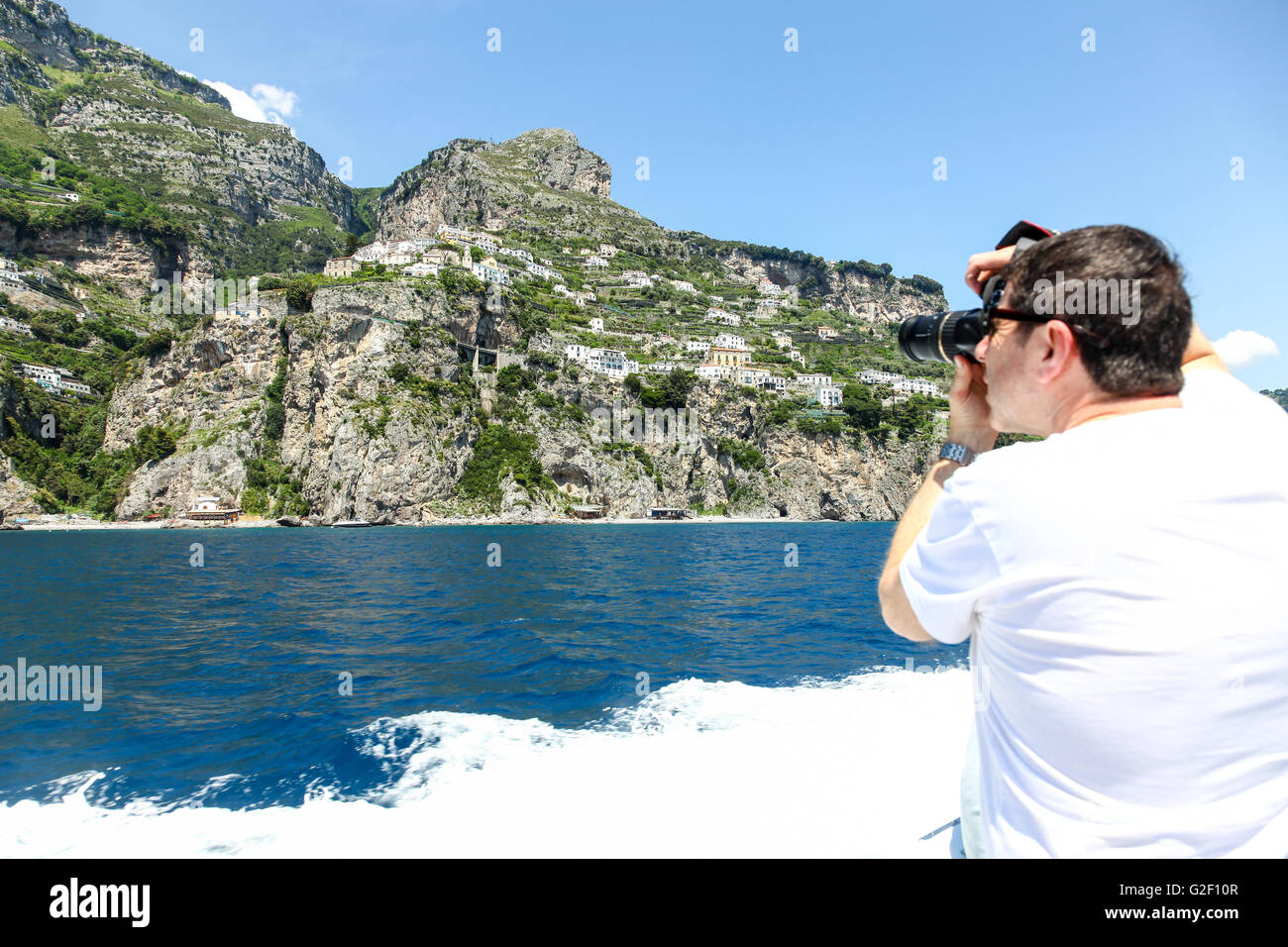 Mann, der ein Foto von der hellen bunten Häusern am Hang von einer Bootsfahrt rund um die Amalfi-Küste-Italien-Europa Stockfoto