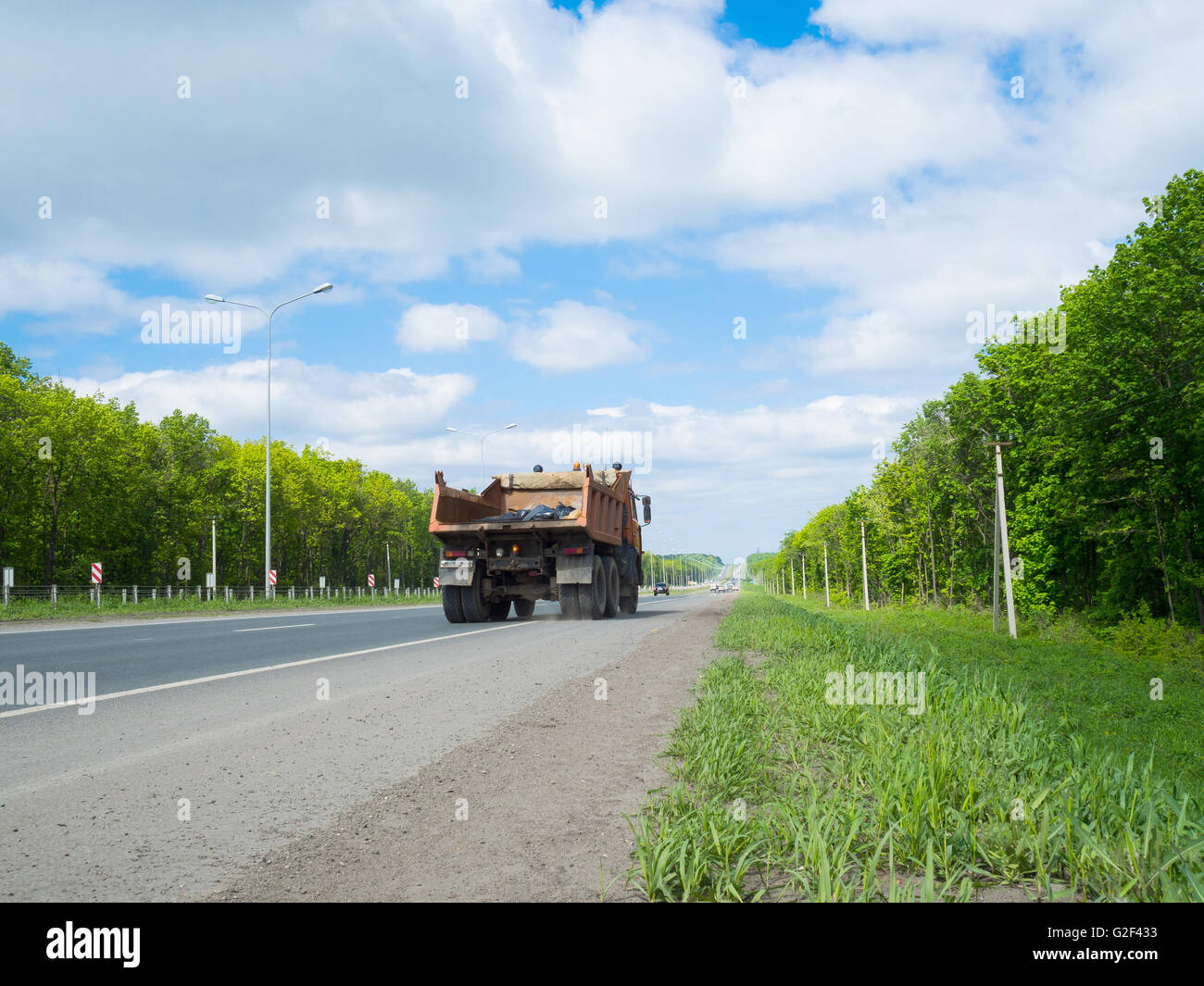 Straße mit Autos und grüne Umgebung seitlich verschieben. Autobahn zurück in die Ferne über den Horizont hinaus. Stockfoto