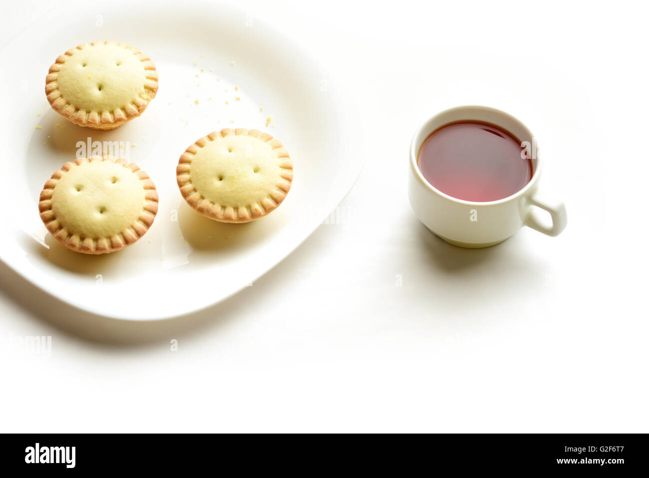 Mürbeteig-Törtchen auf einem Teller mit Tasse Tee Stockfoto