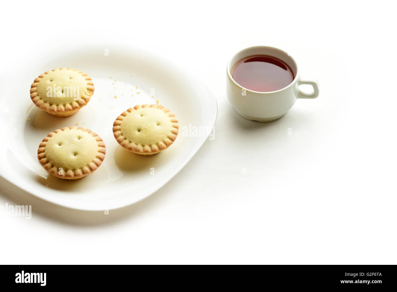 Mürbeteig-Törtchen auf einem Teller mit Tasse Tee Stockfoto