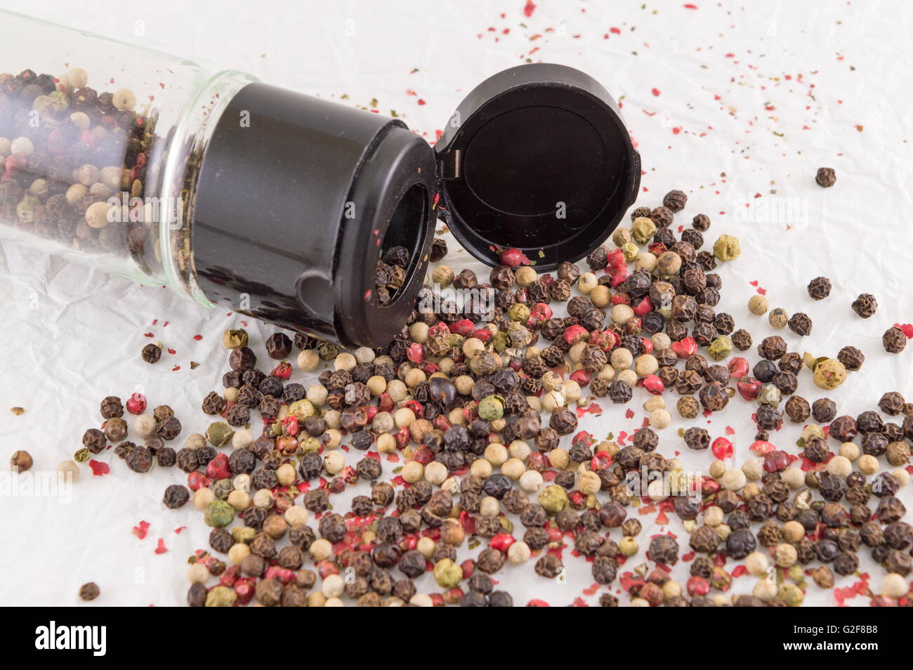 rote und braune Pfeffer Kugeln auf dem weißen Tisch Stockfoto