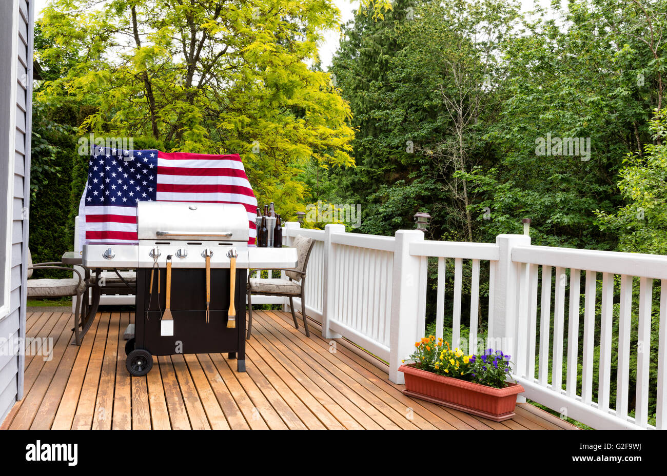 Home Outdoor-Terrasse und Grill Herd mit Eimer kaltes Flaschenbier auf Eis mit hölzernen USA-Flagge im Hintergrund. Stockfoto