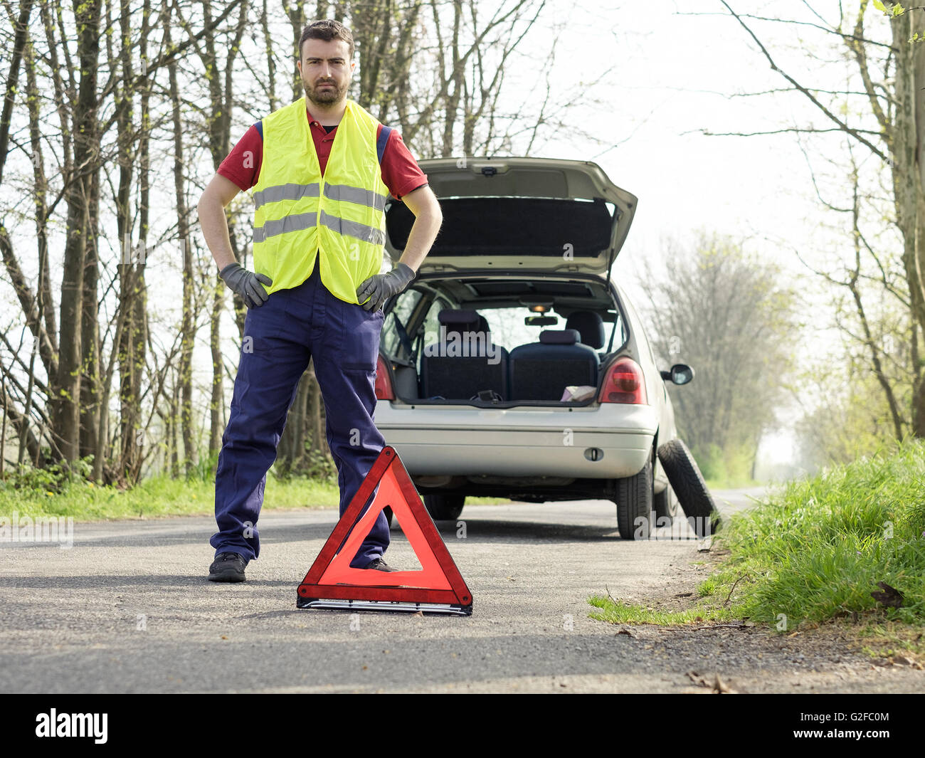 Warndreieck wird aufgestellt und warnt vor Auto mit Panne oder Unfall Stock  Photo