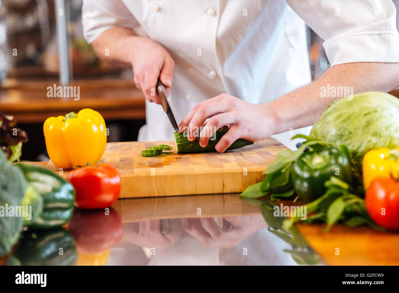 Nahaufnahme des grünen frischen Gurken schneiden durch die Hände von professionellen Koch Köchin in der Küche Stockfoto