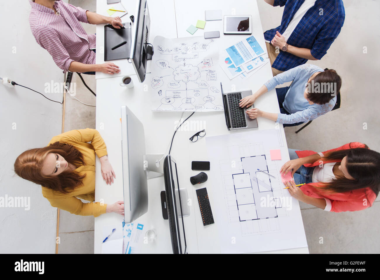 Kreativteam mit Computern, Blaupause im Büro Stockfoto