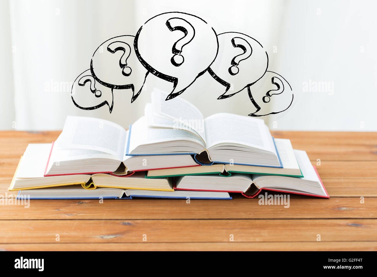 Nahaufnahme von Büchern auf Tisch und Fragezeichen Stockfoto