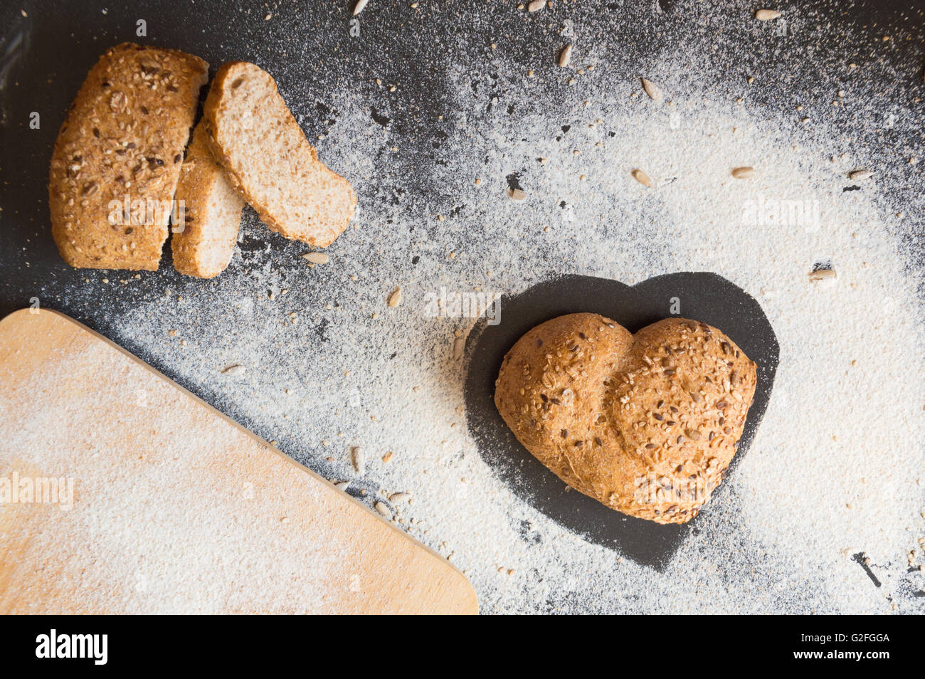 Herzform von Vollkornbrot auf Tafel Hintergrund Stockfoto