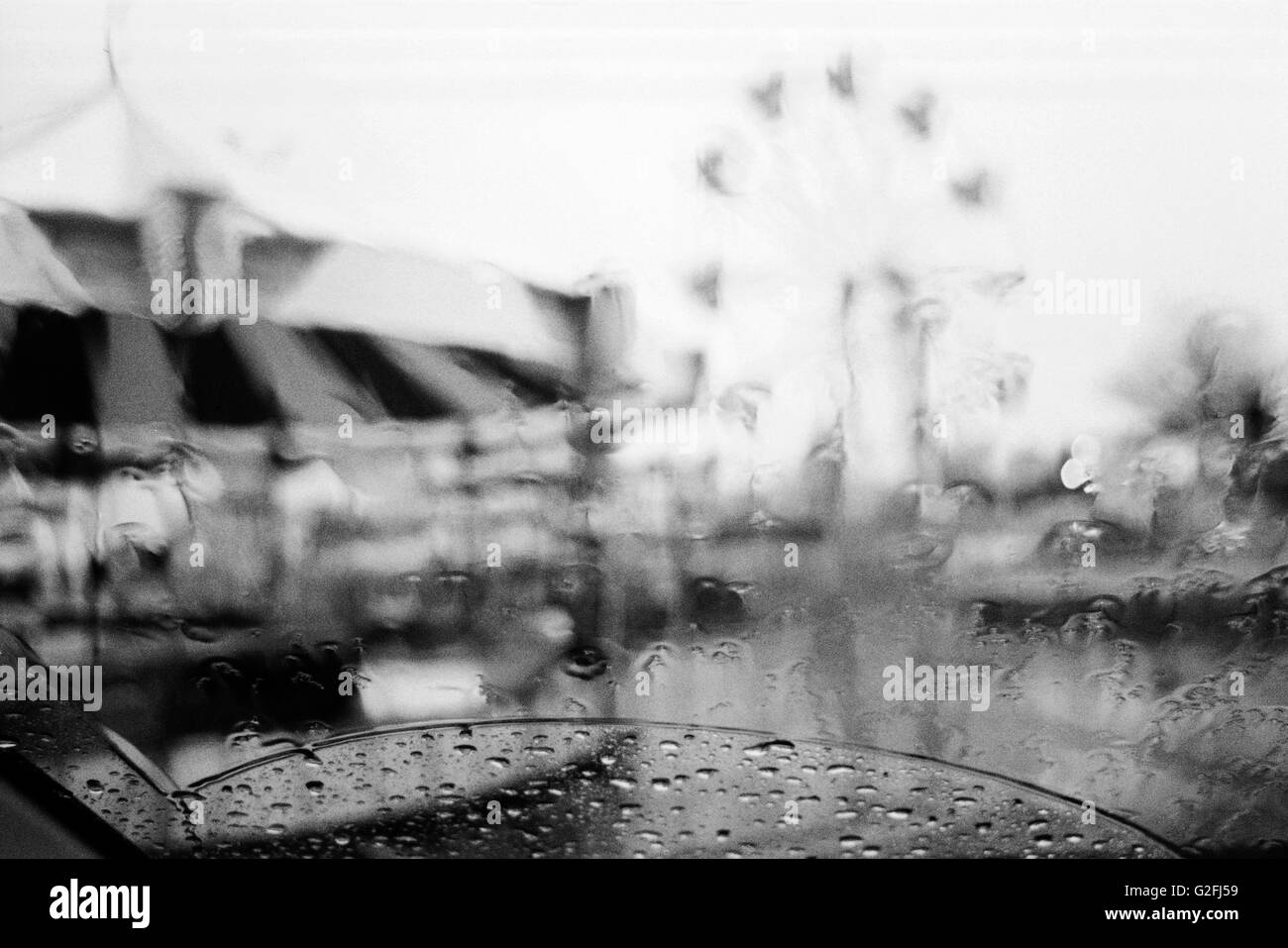 Verschwommene Vergnügungspark von Autofenster im Regen gesehen Stockfoto