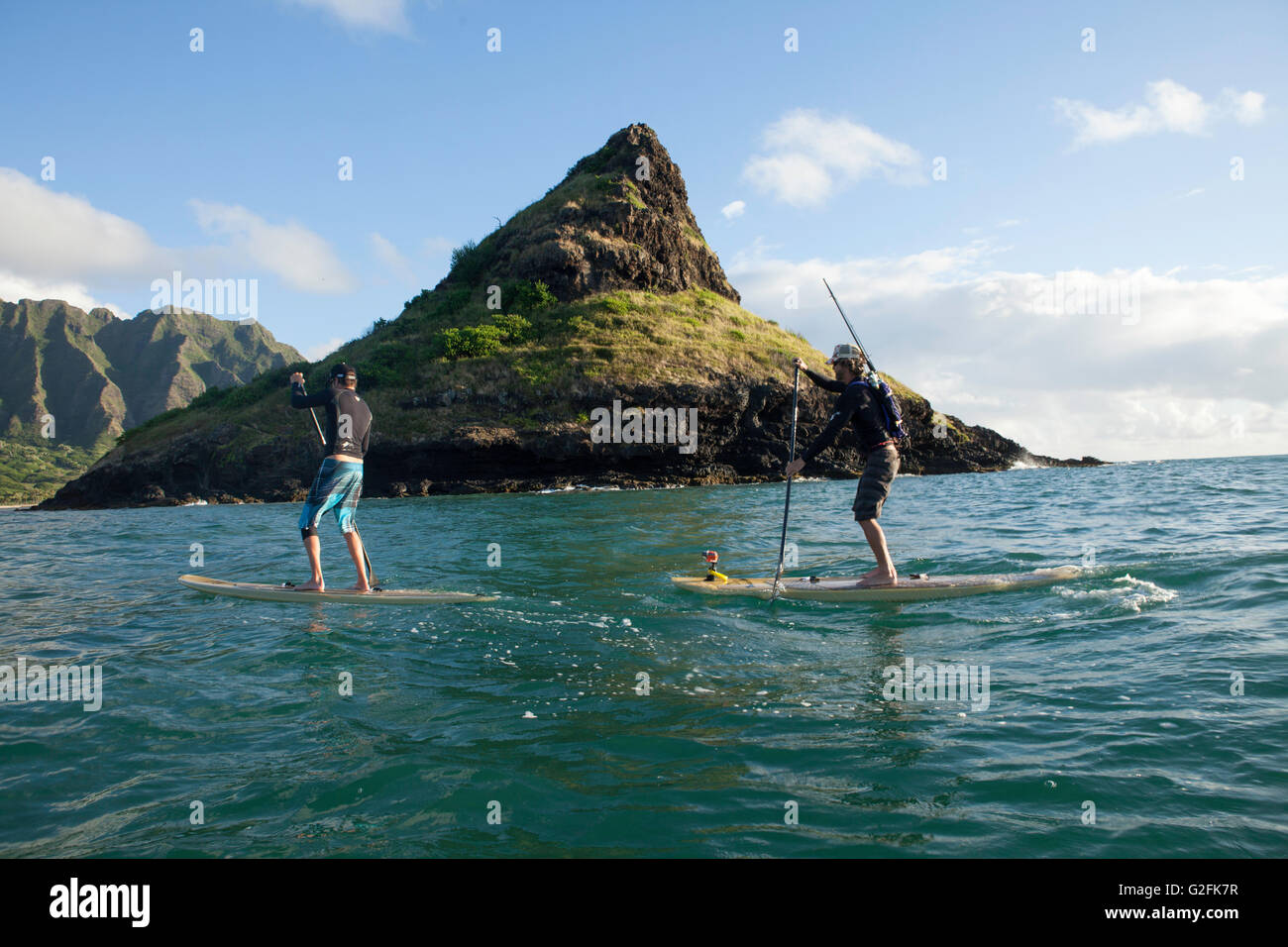 Stand Up Paddle Boarding in Kaneohe Bay bei Kualoa und Mokoli'i Island (früher bekannt als der veraltete Begriff „Chinaman's hat“). Das Koolau-Gebirge ist in Sicht. Stockfoto