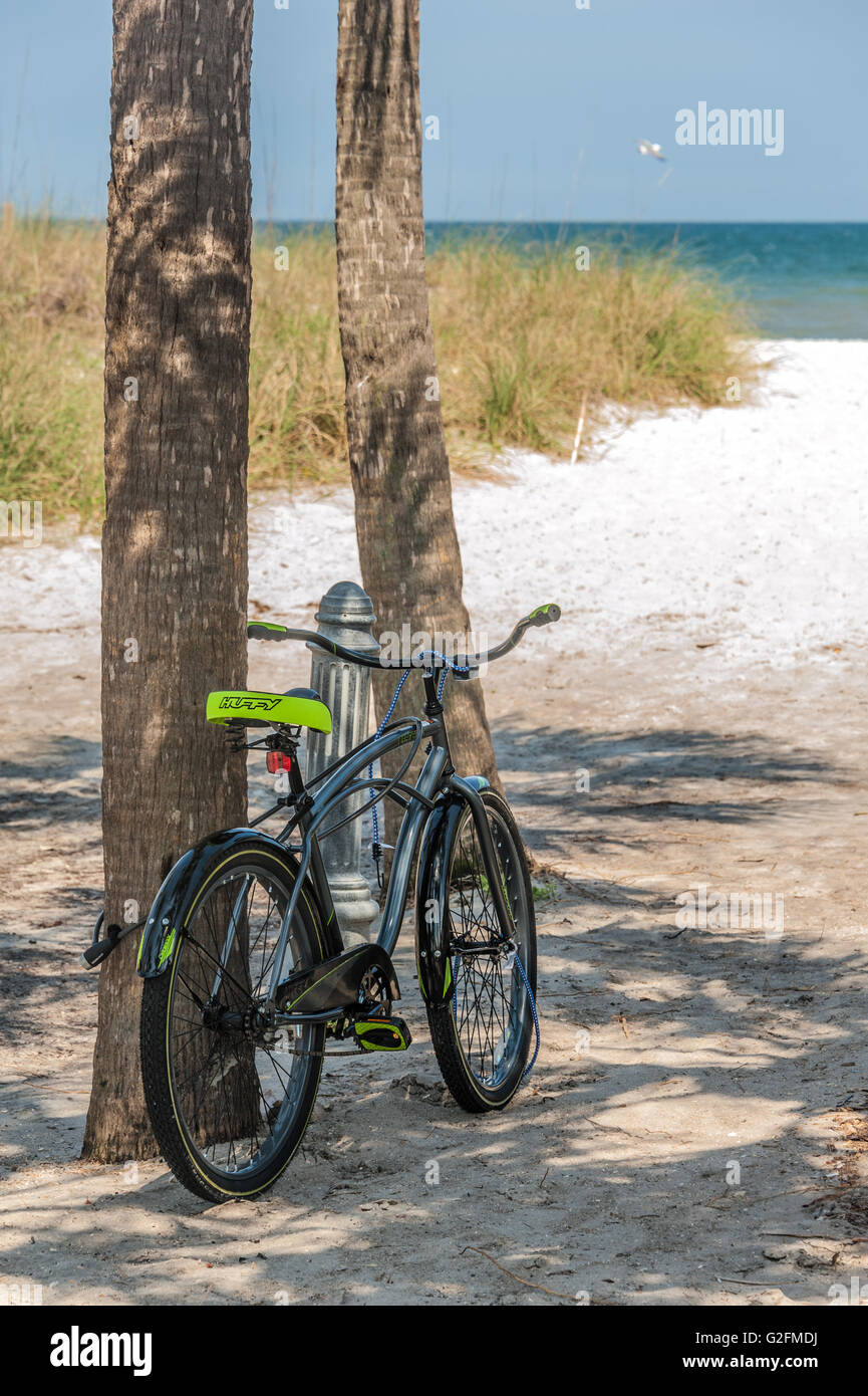 Einzelnes Fahrrad Parken gegen eine Palme auf einem sandigen Strandzugang zu Neptun/Atlantic Beach in Jacksonville, Florida. (USA) Stockfoto