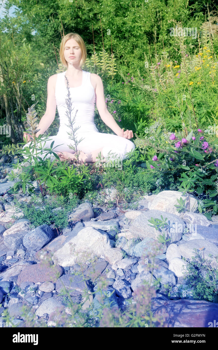 Junge Frau übt Yoga auf dem Rasen im freien Stockfoto