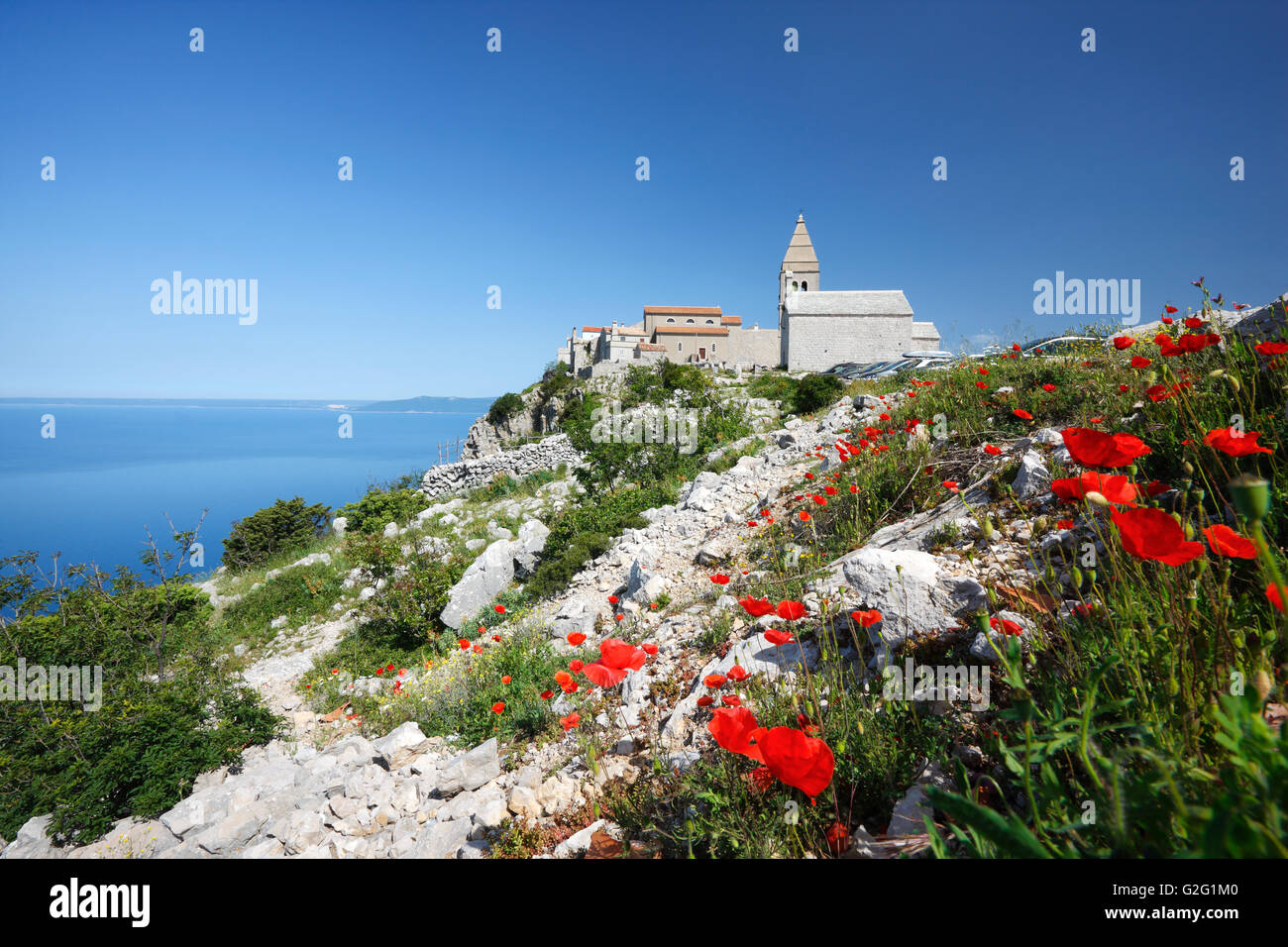 Die hügelige Lubenice-Stadt auf der Insel Cres mit Mohn Blumen in der front Stockfoto