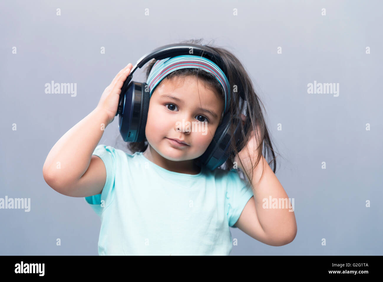 Porträt der schwarzhaarige Mädchen, die Musik im Kopfhörer hören. Studio gedreht Stockfoto