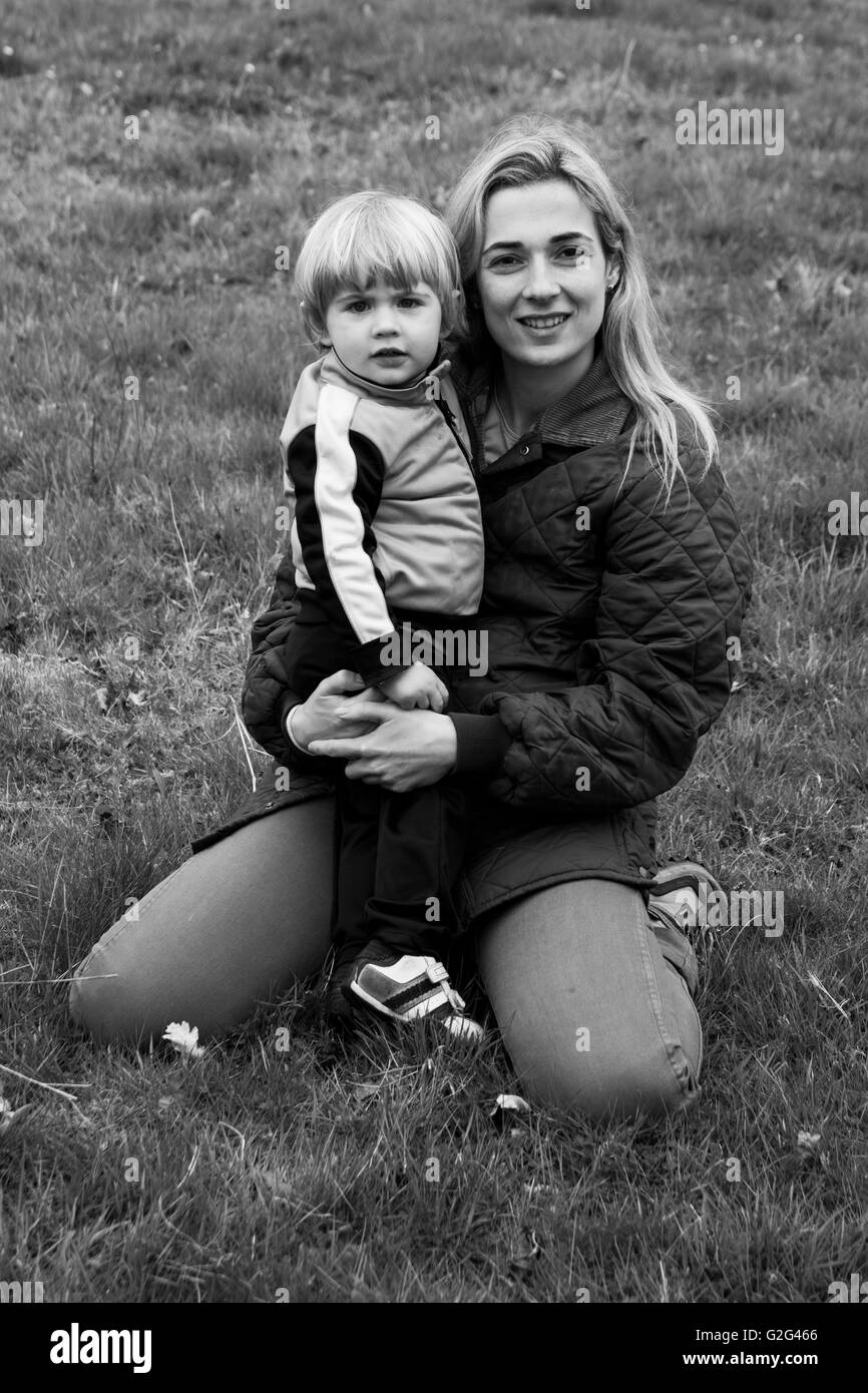 Knienden Mutter mit jungen Sohn in Wiese, Porträt Stockfoto