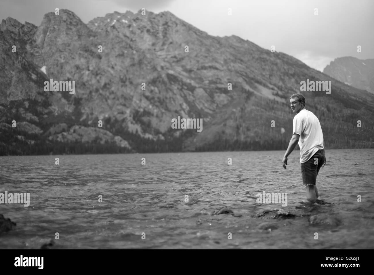 Mann, waten im Bergsee, Grand-Teton-Nationalpark, Wyoming, USA Stockfoto