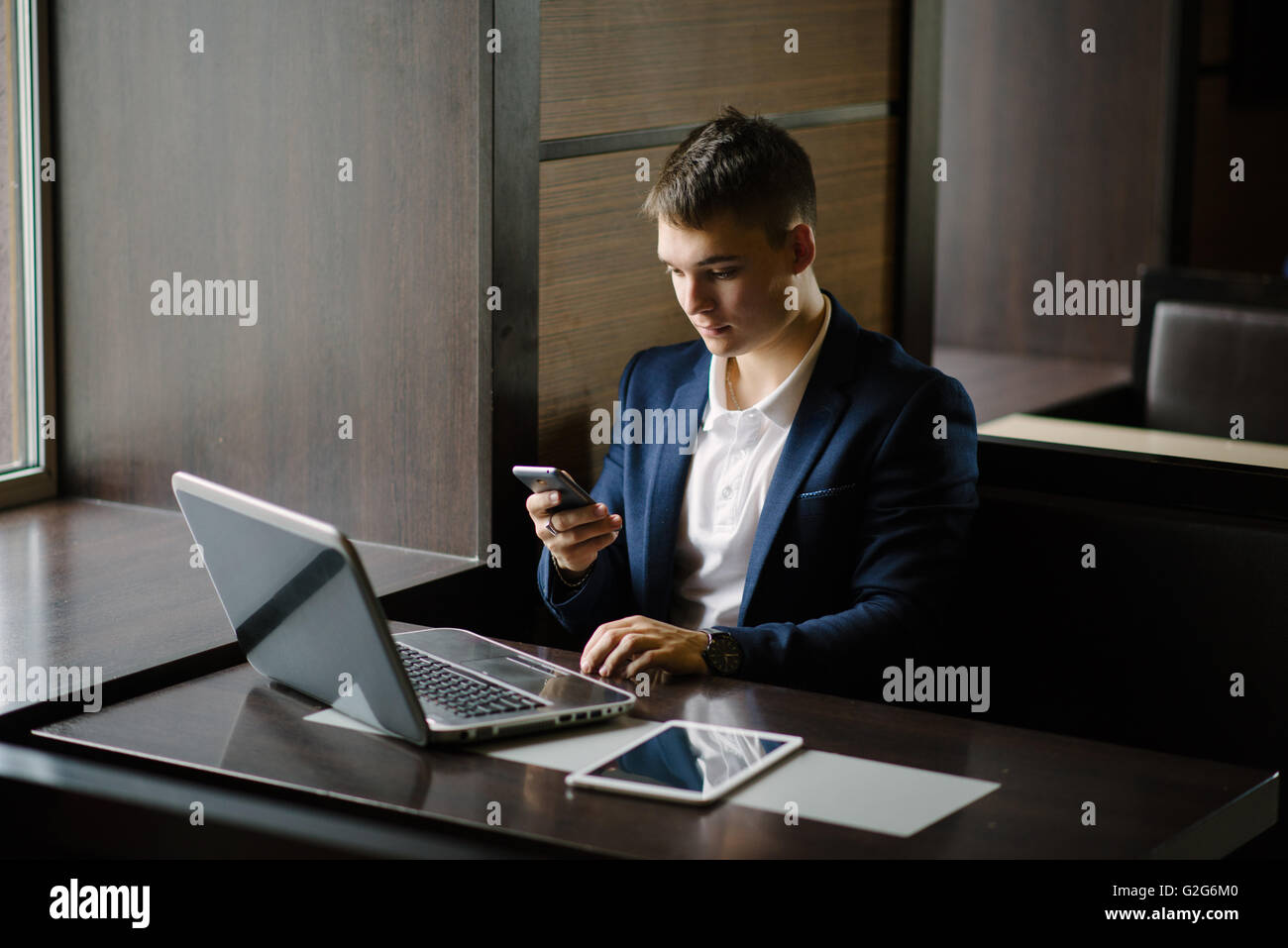 Porträt eines jungen Geschäftsmann auf seinem Smartphone im Café zu sehen. Stockfoto