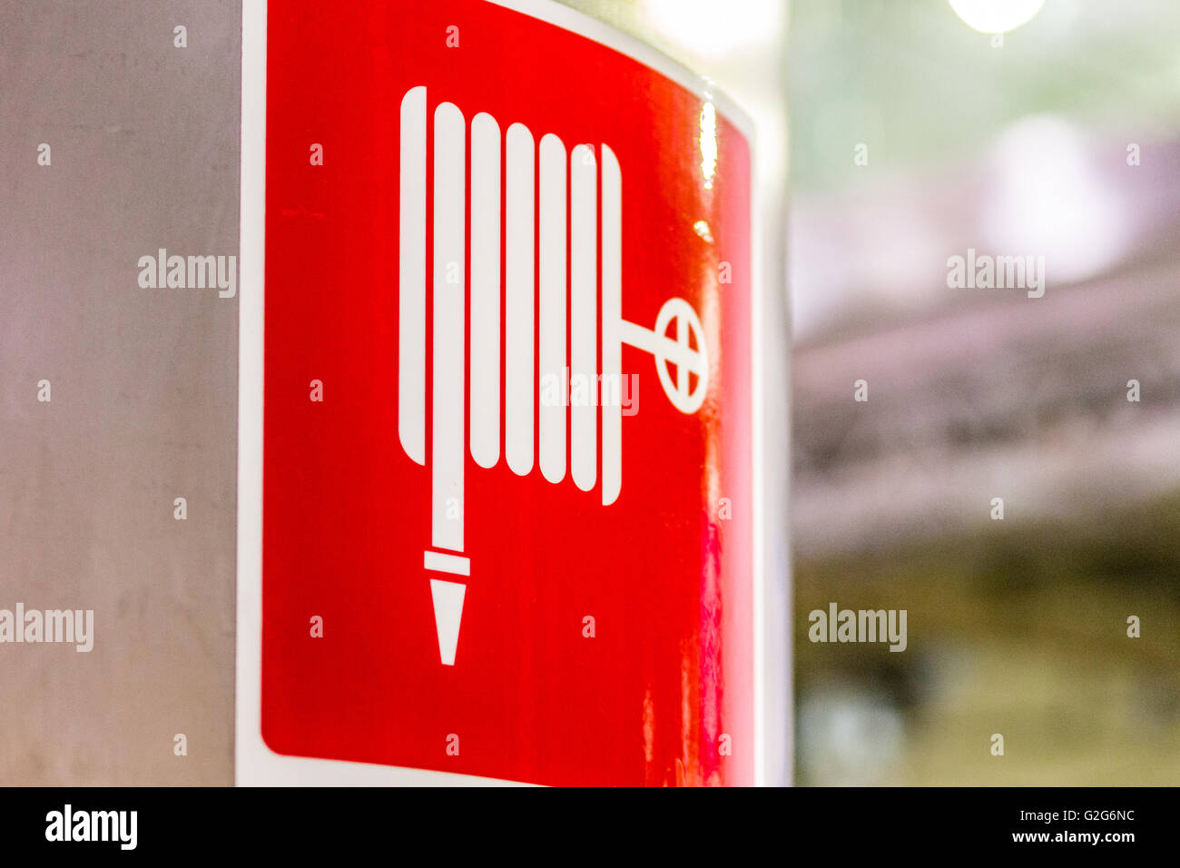 rotes Signal Anzeige von Hydranten und Schlauch Haspel auf Runde Stahlverkleidung Stockfoto