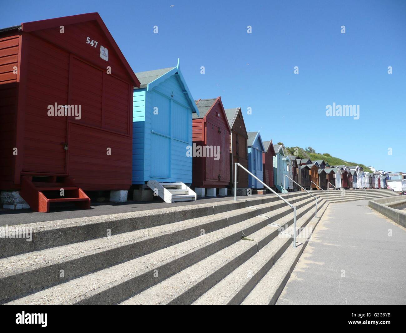 Bunte Strandhäuschen in England mit Treppe zum Strand Stockfoto