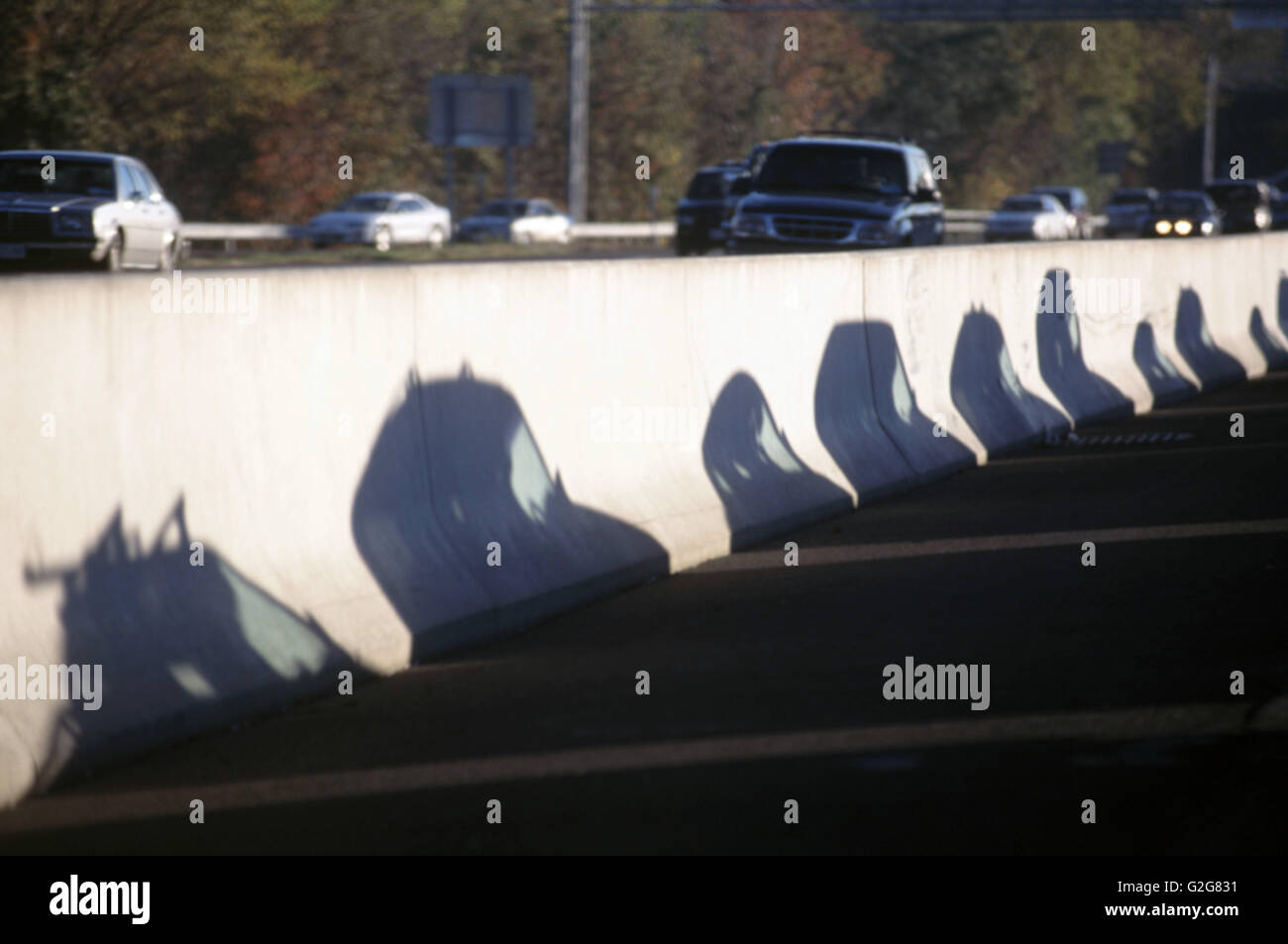 Autobahn-Verkehr. Autos-Schatten erscheinen auf mittlere Betonschutzwand Stockfoto