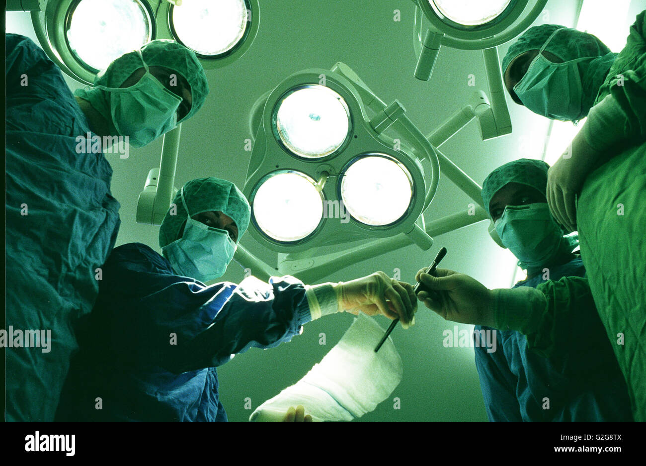 Schweden, Göteborg. Sahlgrenska Krankenhaus. Chirurgen lehnen über einen Patienten im OP-Saal Stockfoto