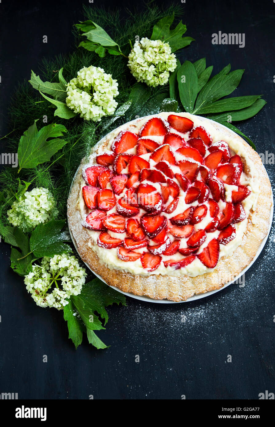 Erdbeeren und Sahne-Torte mit Blumen Dekoration Stockfoto
