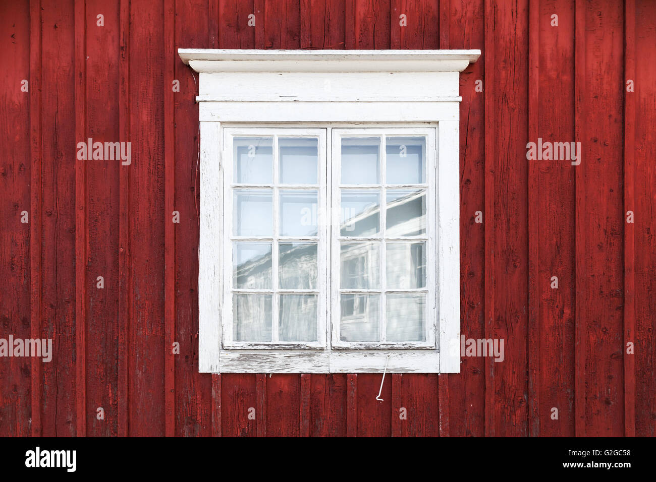 Alte rote Holzwand mit Fenster in weißer Rahmen, typisch skandinavisch Leben Haus Architektur Detail Stockfoto