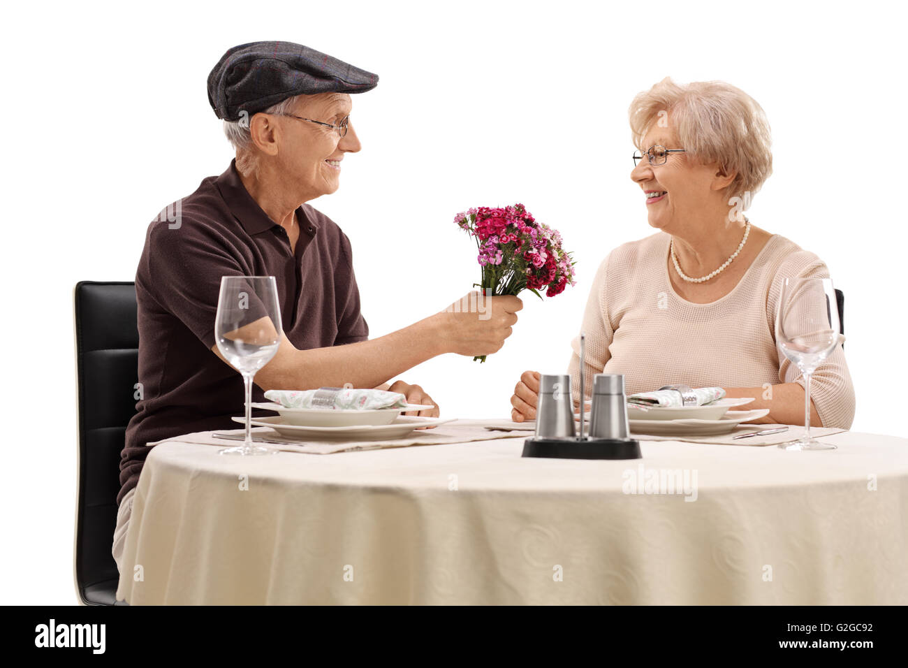 Romantische senior sitzen auf ein Date mit einer Frau und geben ihre Blüten isoliert auf weißem Hintergrund Stockfoto