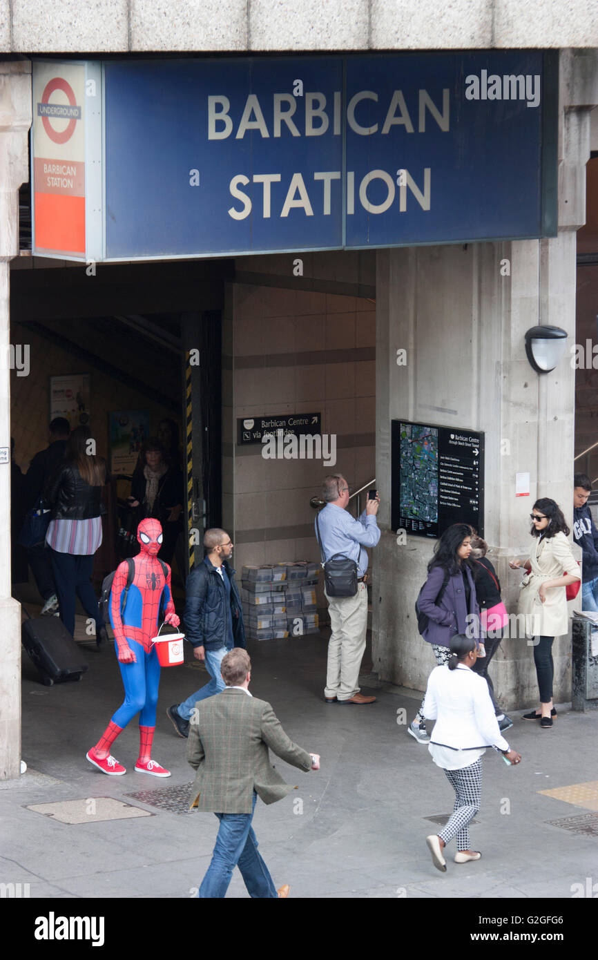 Fancy Dress Charity Sammler außerhalb Barbican Station in Spiderman Outfit mit Sammlung Eimer Stockfoto