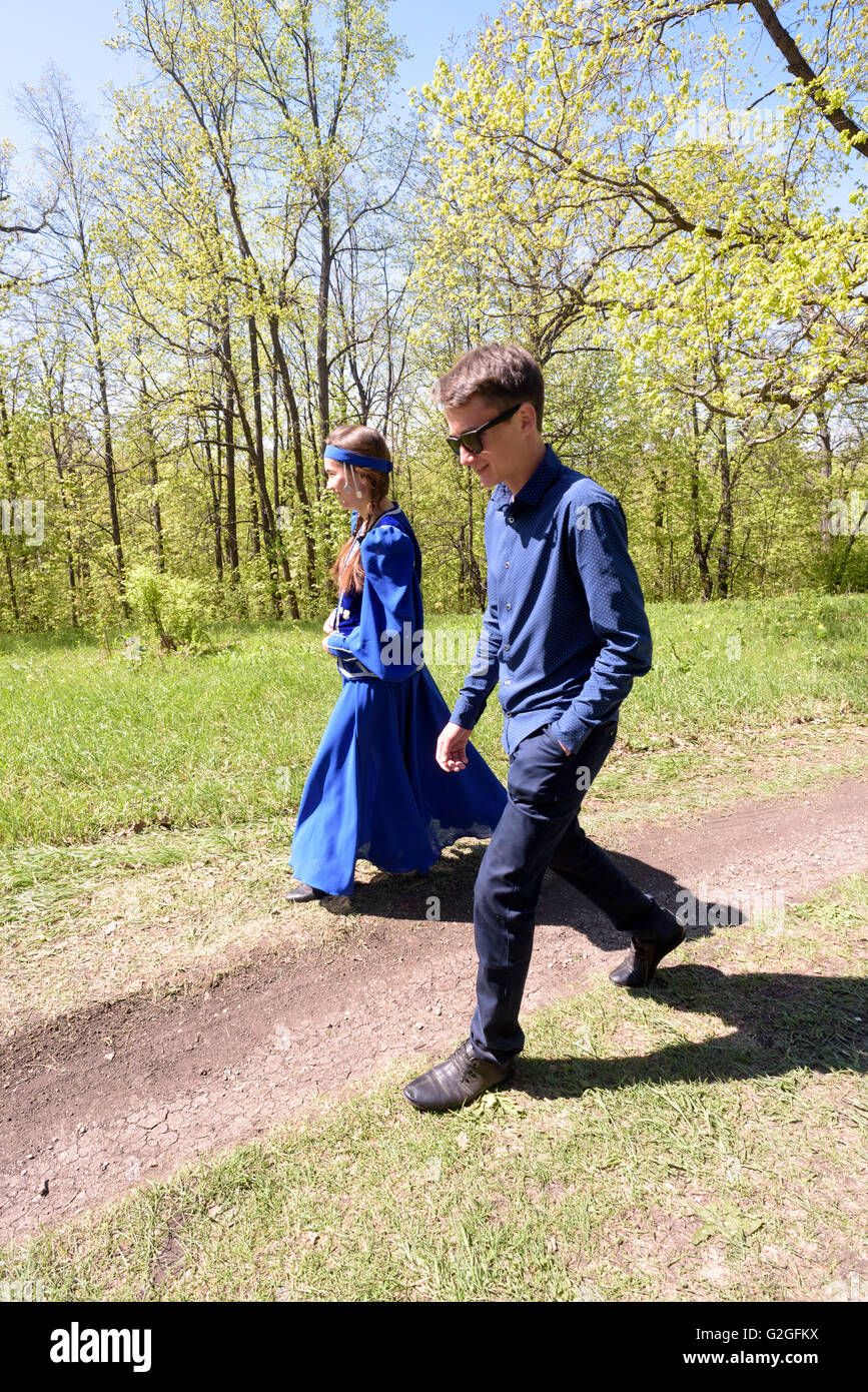 Junge russische Mädchen in traditionellen blau Kostüm aus Russland und ein kleiner Junge auf einem Pfad durch den Wald wandern Stockfoto