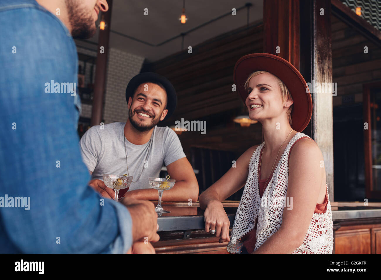 Gruppe junger Freunde sitzen und reden in einem Café. Junge Männer und Frauen in einem Café treffen. Stockfoto