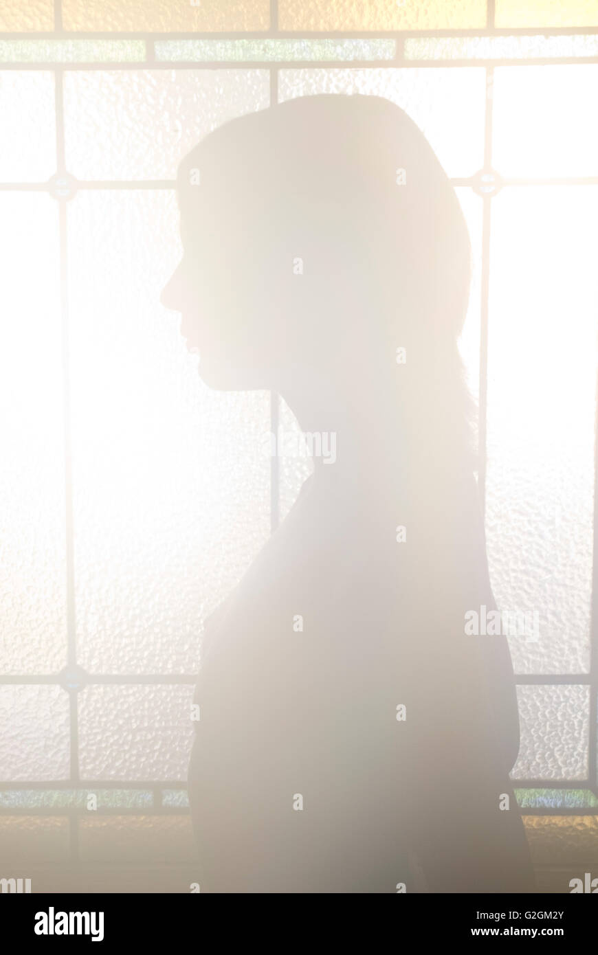 Frauen-Silhouette gegen Glasmalerei Stockfoto