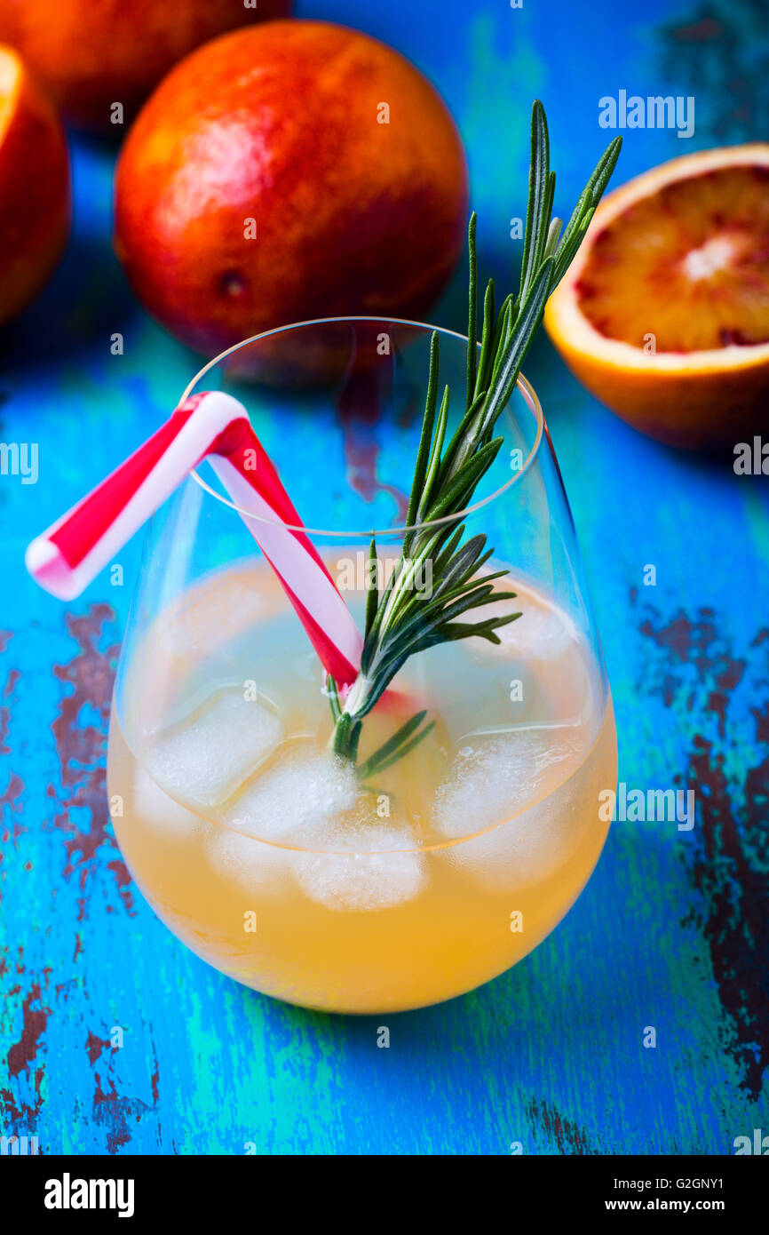 Frisch gepressten Saft und Blutorangen auf blauem Hintergrund, Tequila Palomas mit Rosmarin, Sommer-Getränk Stockfoto