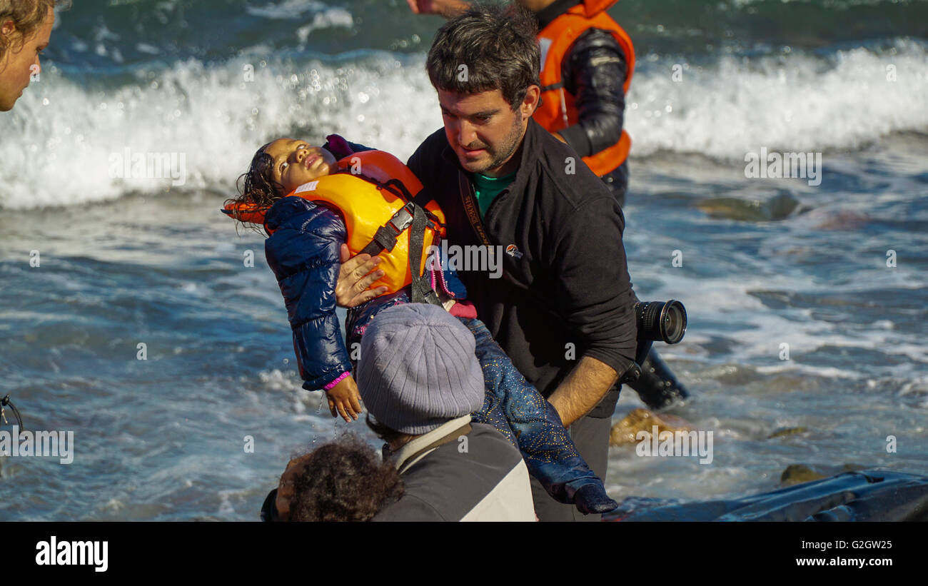 Lesbos, Griechenland - 10. Oktober 2015: Flüchtlinge verlassen das Boot am Ufer. Stockfoto