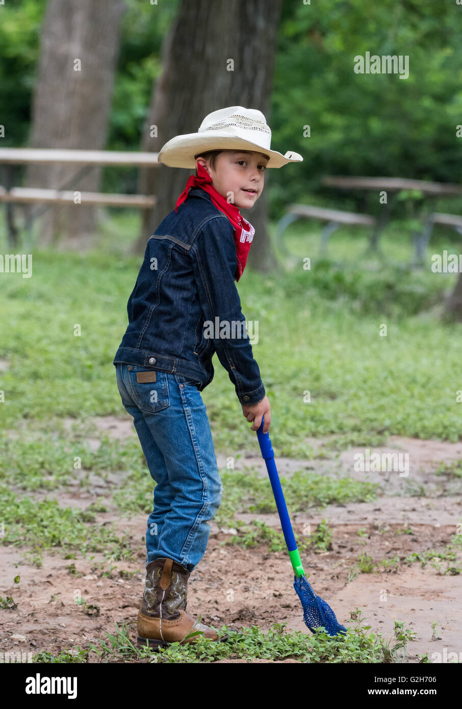 Ein kleiner Junge in Cowboy Kleidung sammeln Frösche und Insekten im McKinney Falls State Park, Austin, Texas. USA. Stockfoto