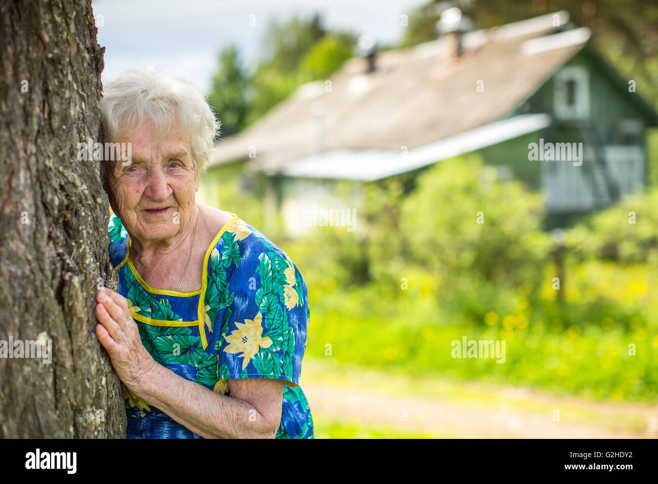 Eine ältere Frau in der Nähe ihrer ländlichen Heimat. Stockfoto