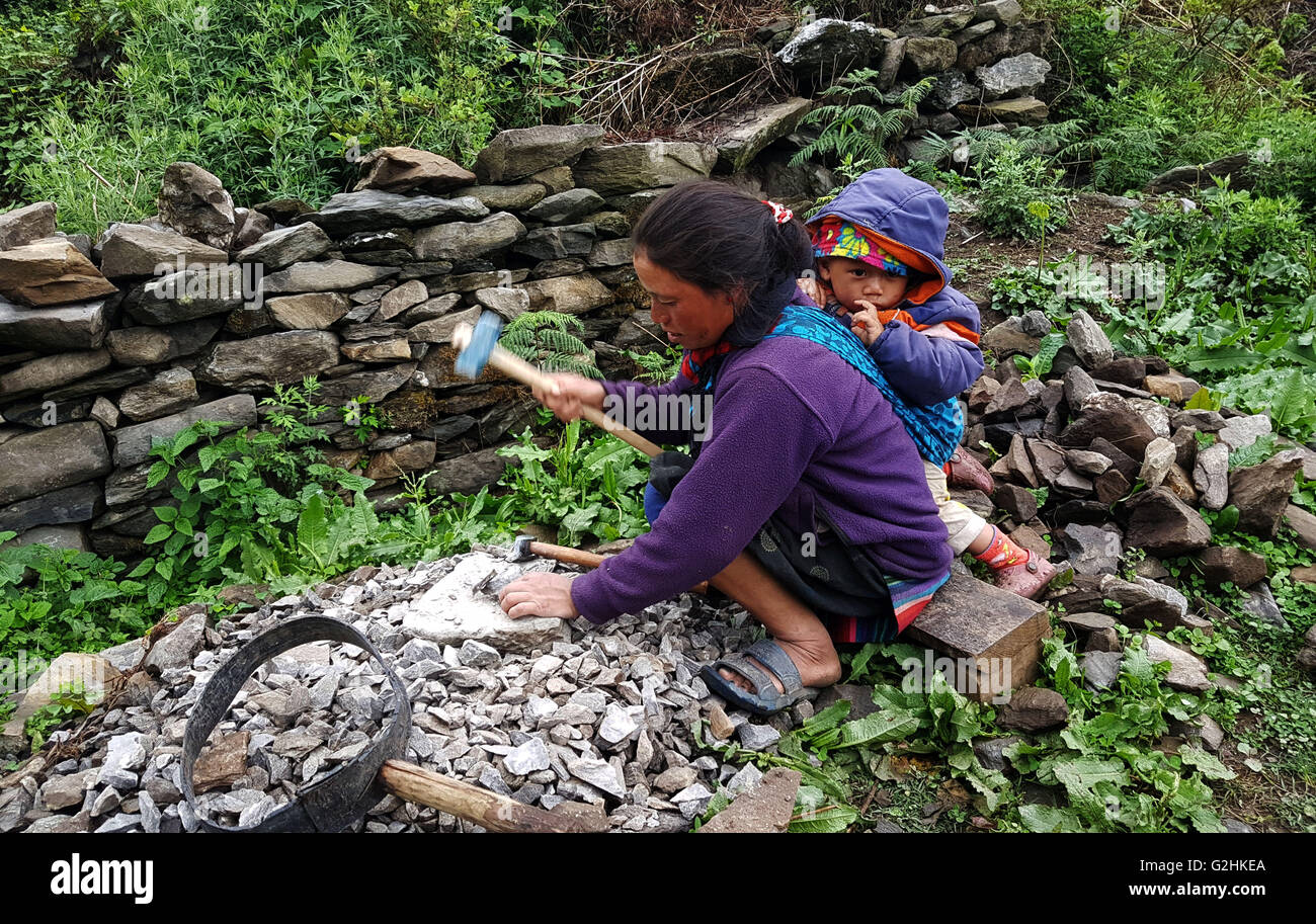 (160531)--RASUWA, 31. Mai 2016 (Xinhua)--eine Frau mit ihrem Baby arbeitet am Standort Wiederaufbau Rasuwa, Nepal, 30. Mai 2016. (Xinhua/Sunil Sharma) (Zjy) Stockfoto