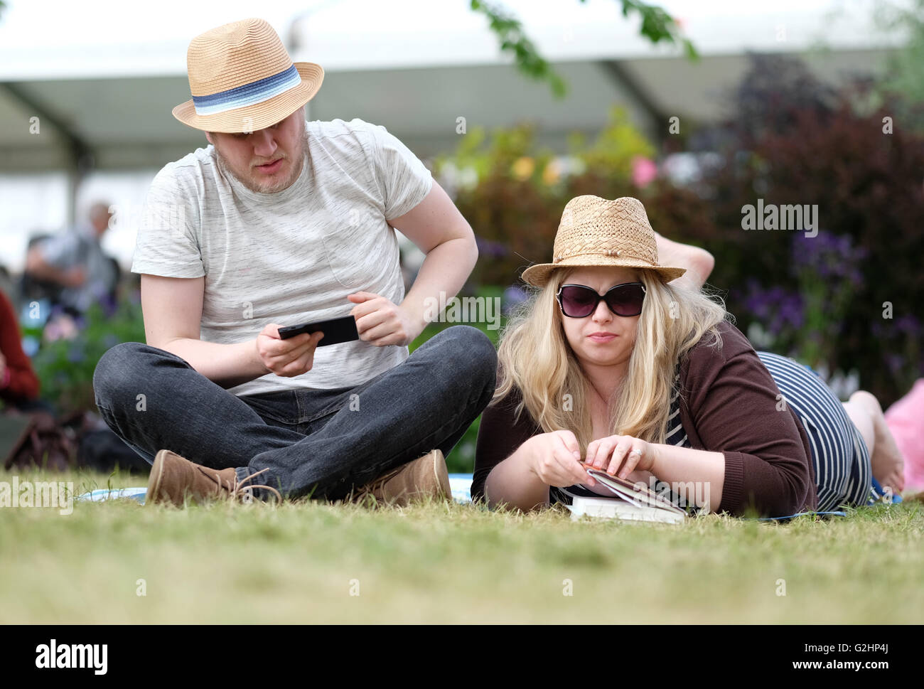 Hay-Festival, Wales, UK - Mai 2016 - ein paar entspannen Sie sich mit etwas zu lesen auf der Festival-Wiese zwischen Ereignissen. Stockfoto