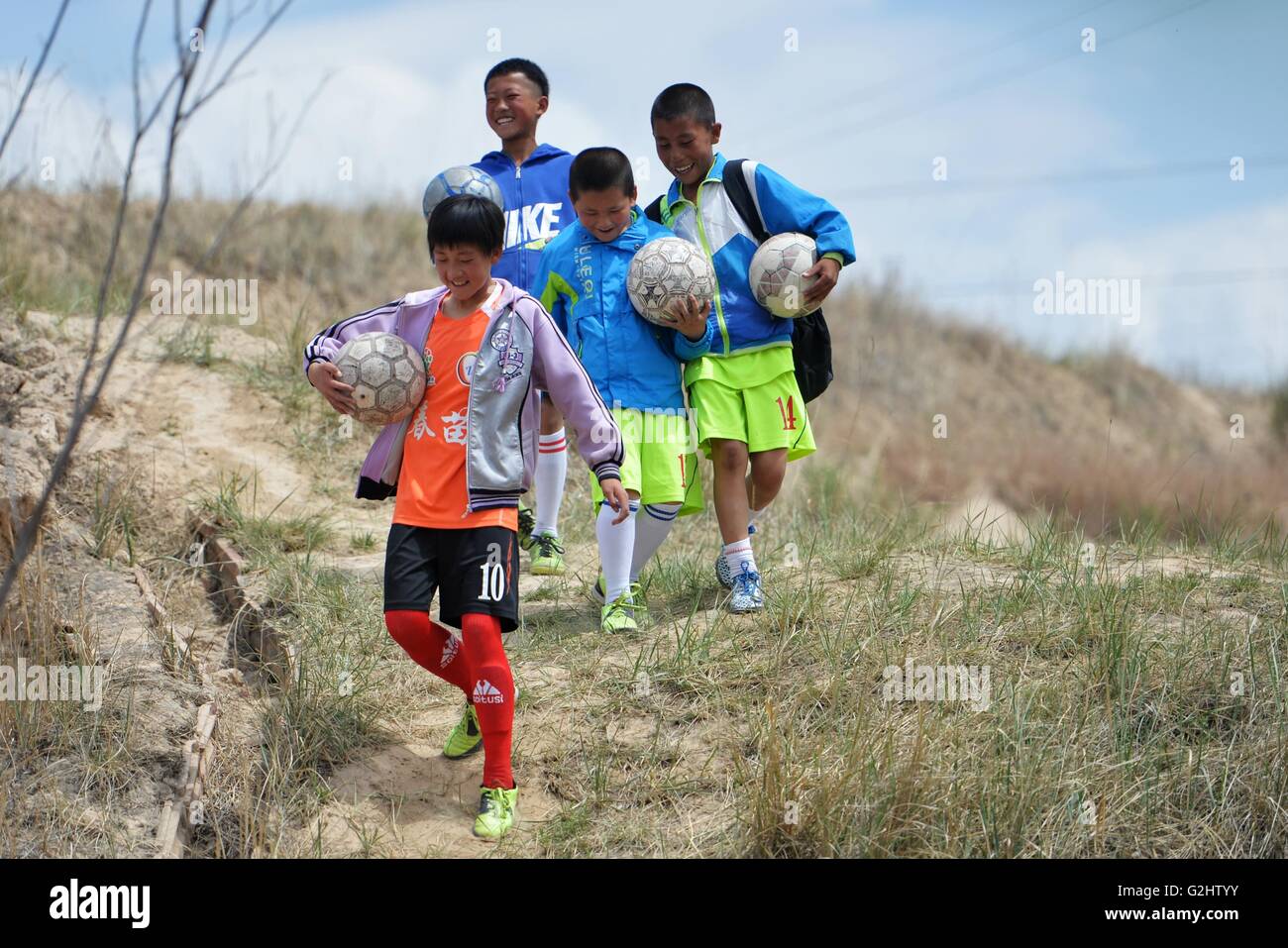 (160601)--LANZHOU, 1. Juni 2016 (Xinhua)--Kinder der Zhonglianchuan Primary School gehen nach der Schule in Yuzhong Grafschaft, Nordwesten Chinas Provinz Gansu, 31. Mai 2016. Fußball bereichert Kinder Alltag an der Schule in den Bereichen ländliche Plateau auf einer Höhe von mehr als 2.300 Metern befindet. Viele Kinder haben die Möglichkeit zur Teilnahme an Fußball-Spiele in den großen Städten. Schulleiter Ma Anwu zu hoffen, dass Fußball mehr ländlichen Studenten Schritt aus den Bergen helfen könnte. Mittwoch ist Internationaler Kindertag. Kinder auf dem Plateau halten ein besonderes Fußballspiel, t zu feiern Stockfoto