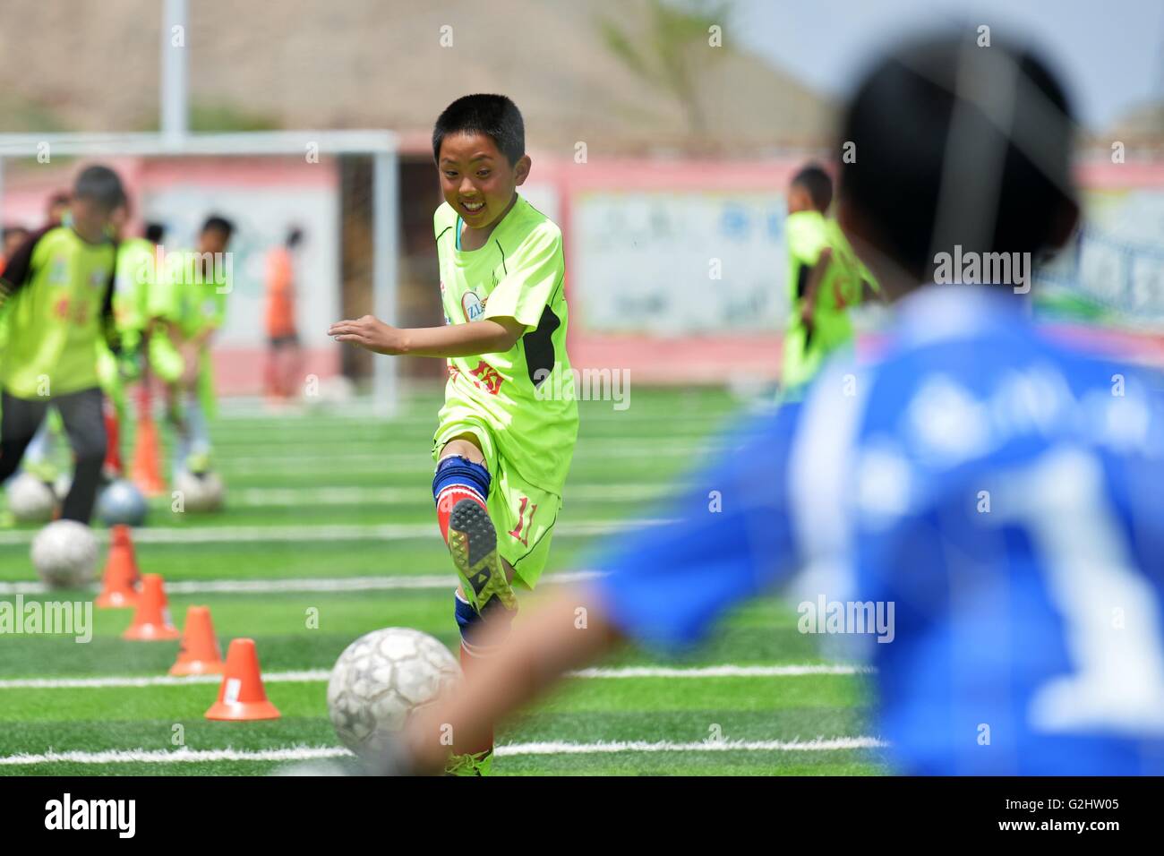 (160601)--LANZHOU, 1. Juni 2016 (Xinhua)--Li Rongli, ein Mitglied der Schulmannschaft spielt Fußball in einem Bohrer in der Zhonglianchuan Primary School Fußball spielen nach der Schule in Yuzhong Grafschaft, Nordwesten Chinas Provinz Gansu, 31. Mai 2016. Fußball bereichert Kinder Alltag an der Schule in den Bereichen ländliche Plateau auf einer Höhe von mehr als 2.300 Metern befindet. Viele Kinder haben die Möglichkeit zur Teilnahme an Fußball-Spiele in den großen Städten. Schulleiter Ma Anwu zu hoffen, dass Fußball mehr ländlichen Studenten Schritt aus den Bergen helfen könnte. Mittwoch ist Internationaler Kindertag. Kind Stockfoto