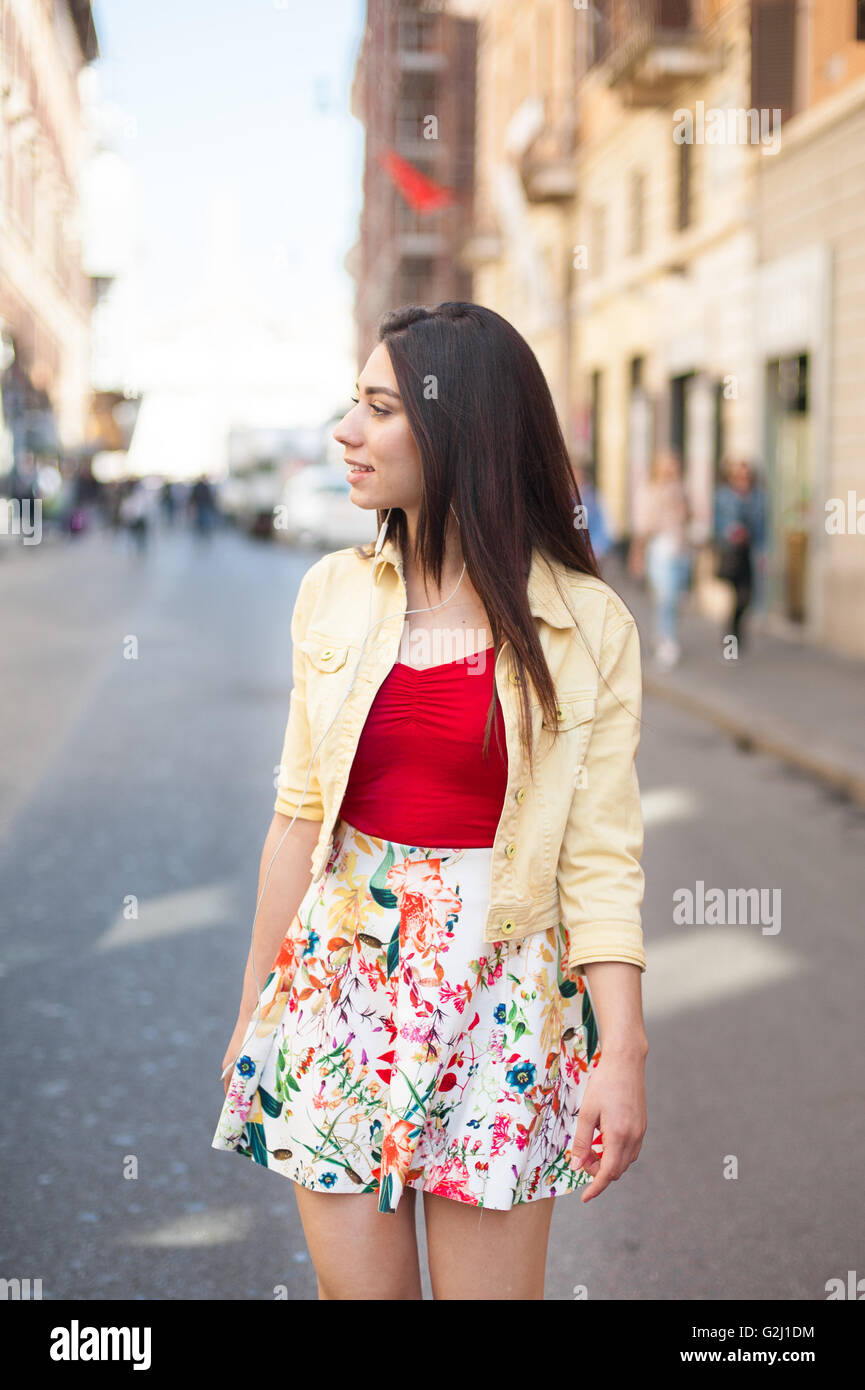 Junge hübsche Frau zu Fuß in die Stadt im Sommer lächelt und schaut sich um Stockfoto