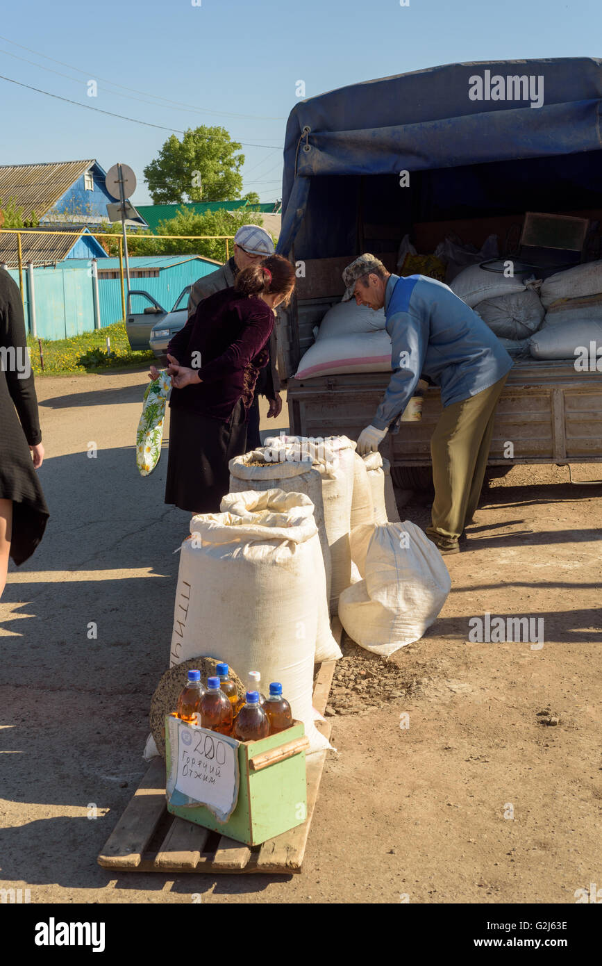 Mann im Gespräch mit Kunden an seinem Marktstand Hühnerfutter in Russland während Mai 2016 Stockfoto