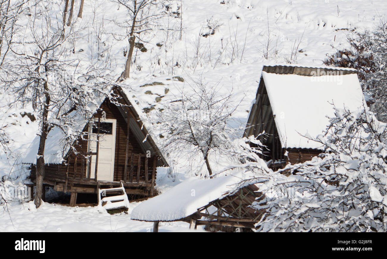 ein Blockhaus im Schnee an einem Berghang Stockfoto