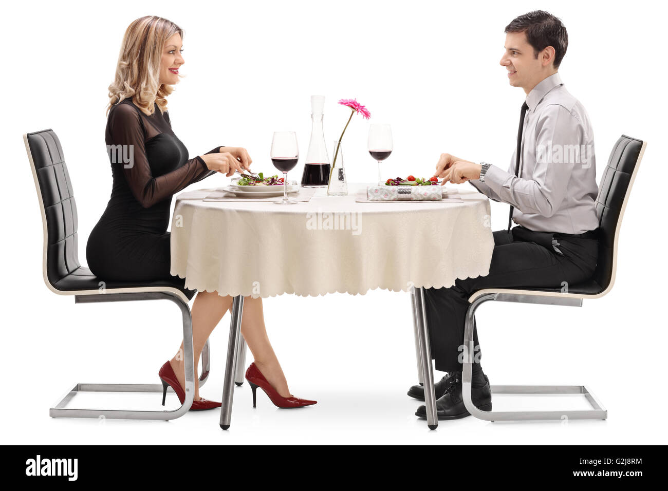 Junger Mann und Frau Essen an einem Tag sitzen an einem Tisch im Restaurant isoliert auf weißem Hintergrund Stockfoto