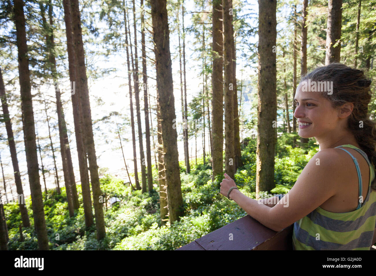 Eine junge Frau sieht durch Wald am China Tag Nutzung Strandbereich in Juan de Fuca Provincal Park Vancouver Island BC Kanada. Stockfoto