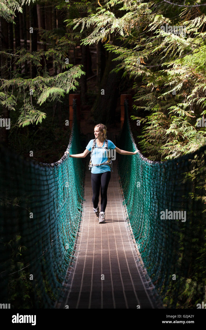 Junge Frau Wanderer auf Hängebrücke zwischen China Beach und Mystic Beach entlang Juan de Fuca Trail Vancouver Island BC Kanada. Stockfoto