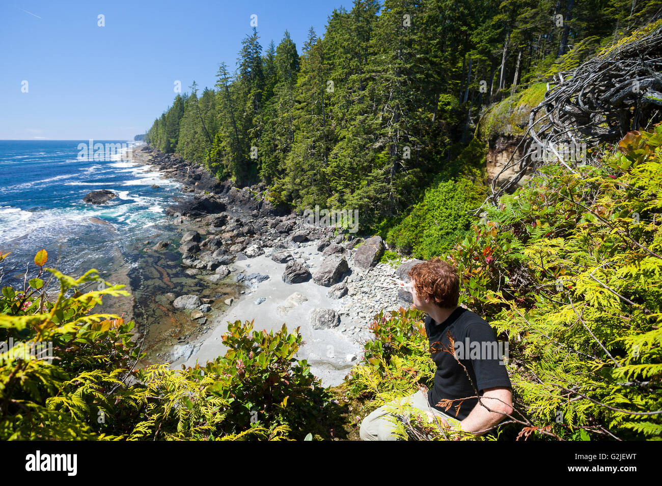 Ein Wanderer sieht nördlich von einer Klippe entlang der West Coast Trail. Pacific Rim National Park Reserve, Vancouver Island, BC, Kanada Stockfoto
